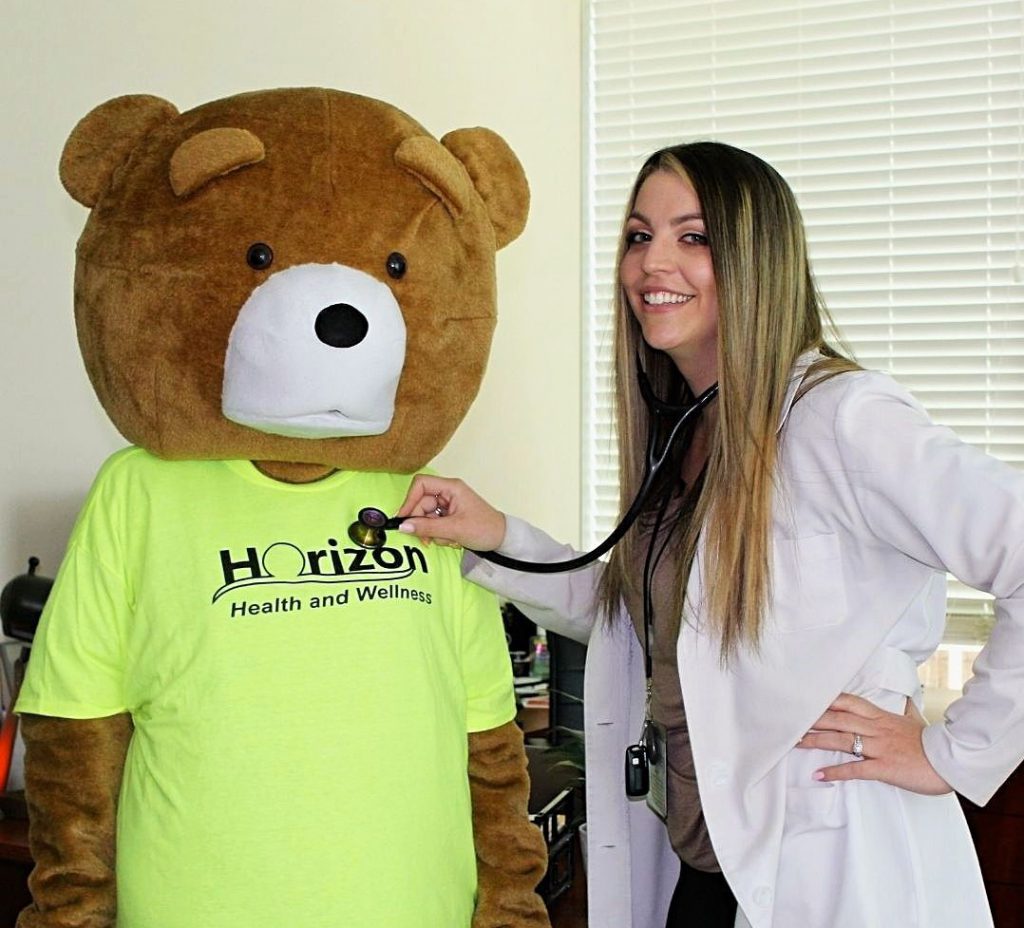 Cubby the Bear getting his heart checked by our doctor with a stethoscope.
