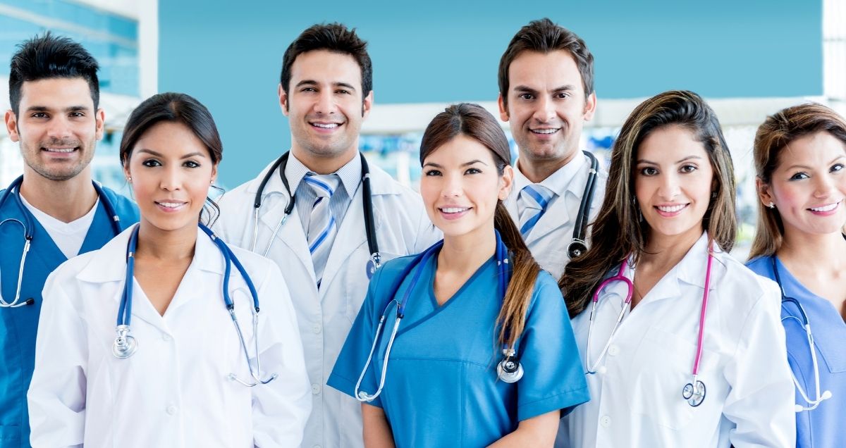 A diverse group of doctors and nurses wearing stethoscopes in a hospital setting.