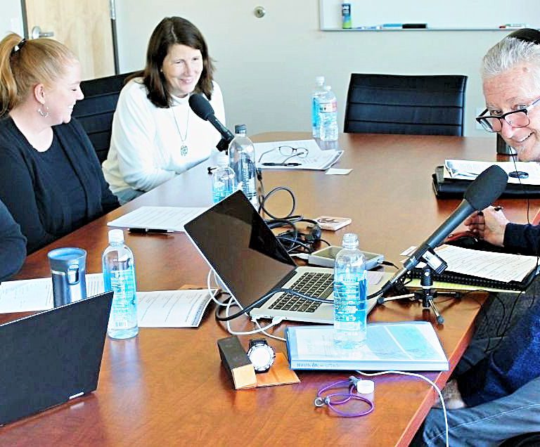 A radio interview in a conference room with three Horizon employees and the show host wearing headphones.