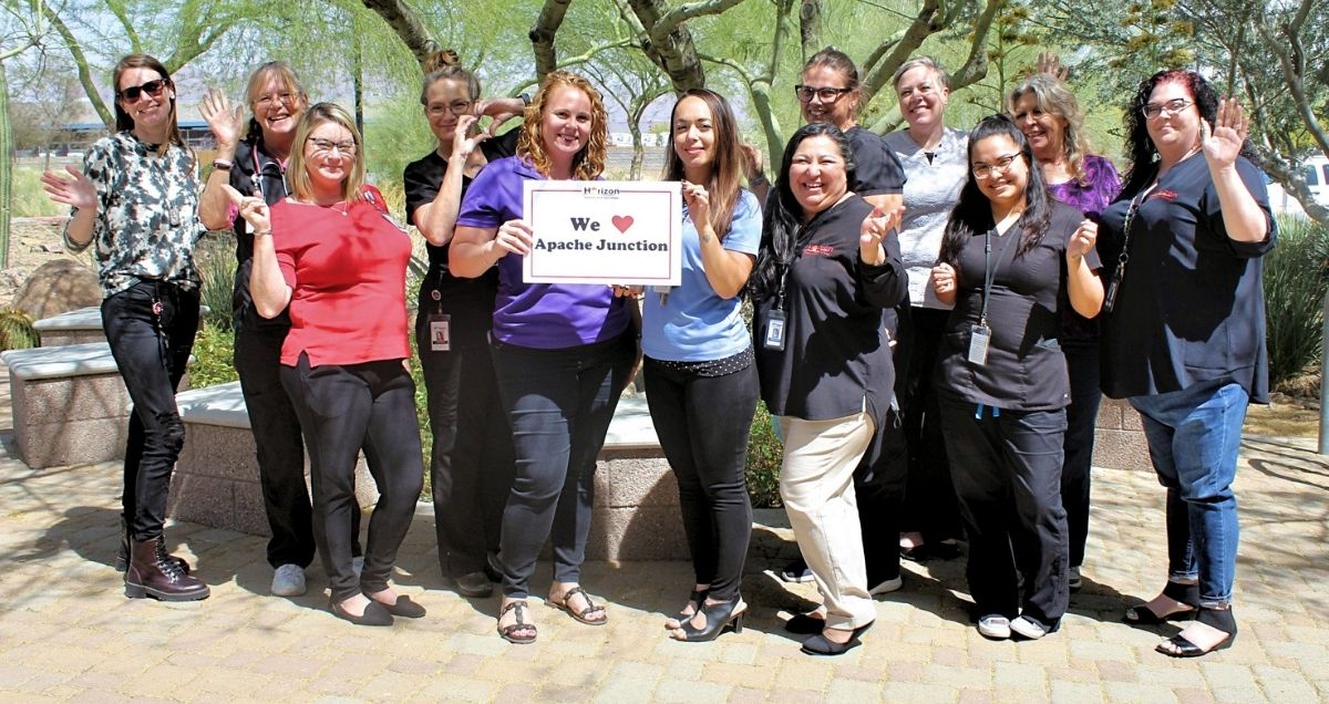 The Horizon Health and Wellness staff at the Apache Junction holding a "Apache Junction" sign.