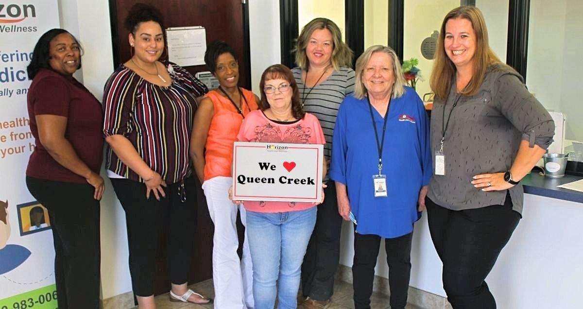 The Horizon Health and Wellness staff at the Queen Creek Clinic holding a "We love Queen Creek" sign.