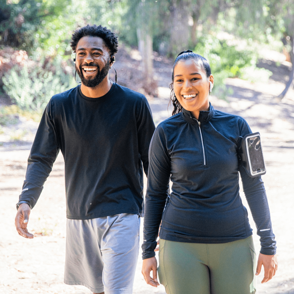 Two diverse adults smiling and walking outside in Queen Creek, AZ after a workout, showing the benefits of a medical weight loss program.